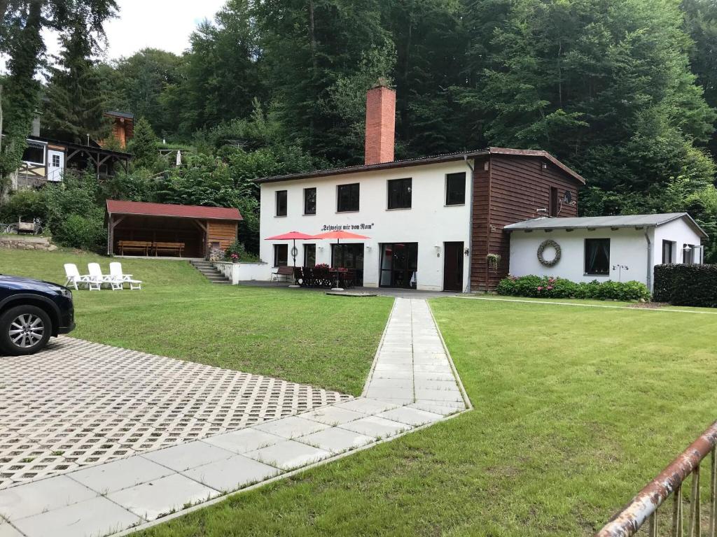 uma casa branca com uma chaminé de tijolo e um quintal em Upscale holiday home in Bad Stuer with terrace and garden em Stuer