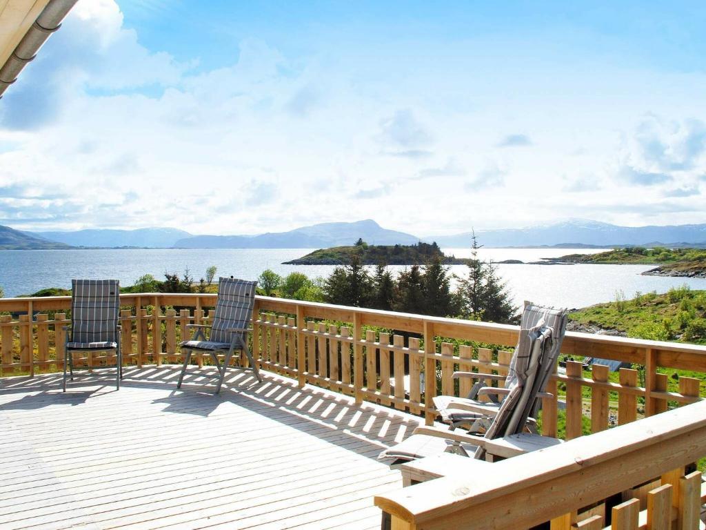 two chairs on a deck with a view of the water at 6 person holiday home in Dønna in DÃ¸nnes