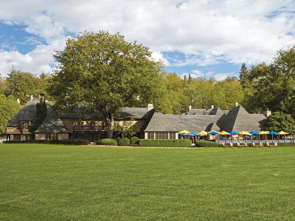 een groot huis met parasols op een gazon bij UCLA Lake Arrowhead Lodge in Lake Arrowhead