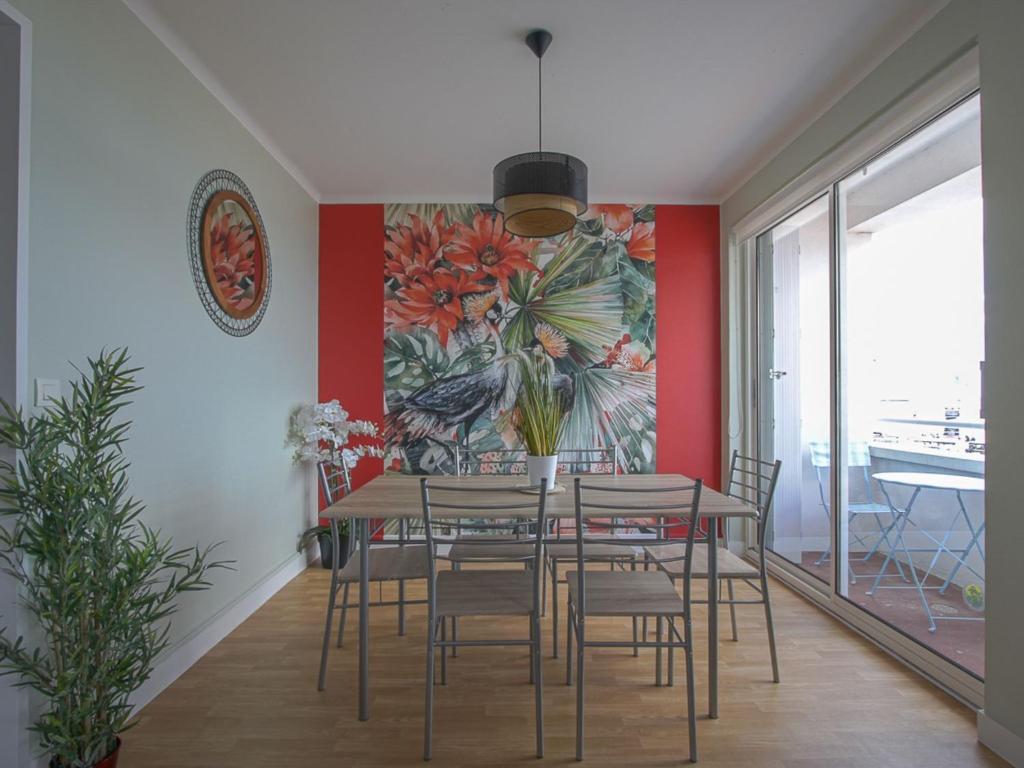 a dining room with a table and chairs and a painting at Comfortable apartment facing the museum in Arromanches-les-Bains