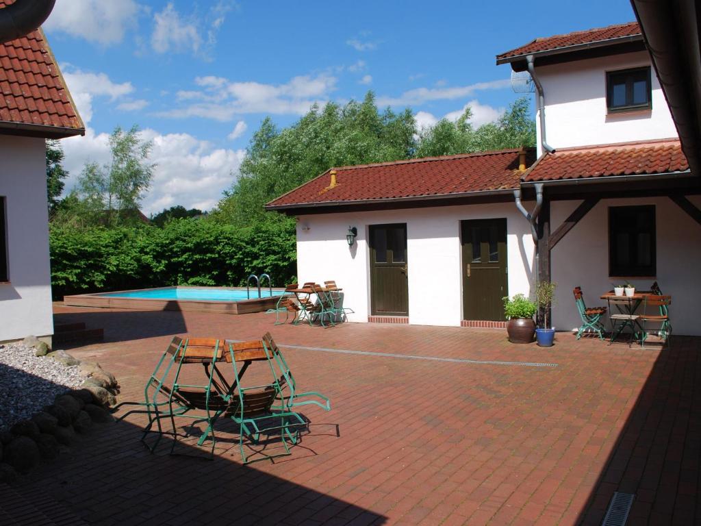 une terrasse avec des chaises et des tables ainsi qu'une maison dans l'établissement Comfortable apartment in Dargun Mecklenburg with Garden, à Barlin