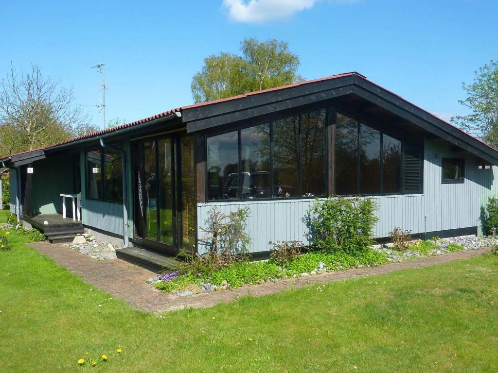 a black and white house with glass windows at 6 person holiday home in Str by in Strøby