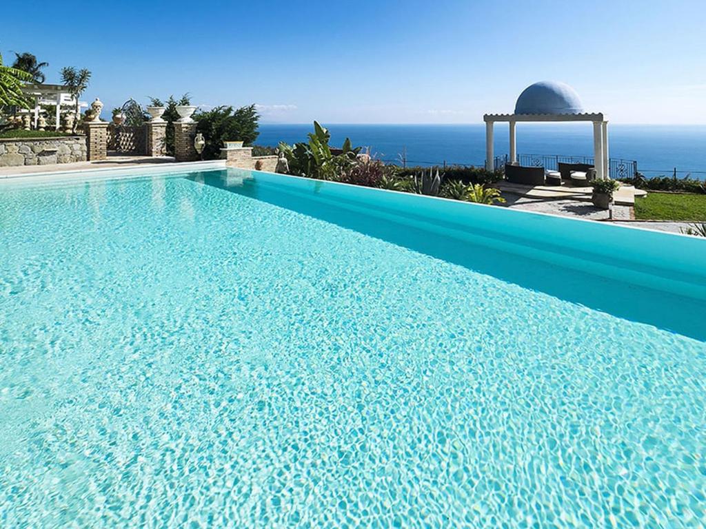 レトイアンニにあるModern Villa in Letojanni with Private Poolの海を背景にした青い大型スイミングプール