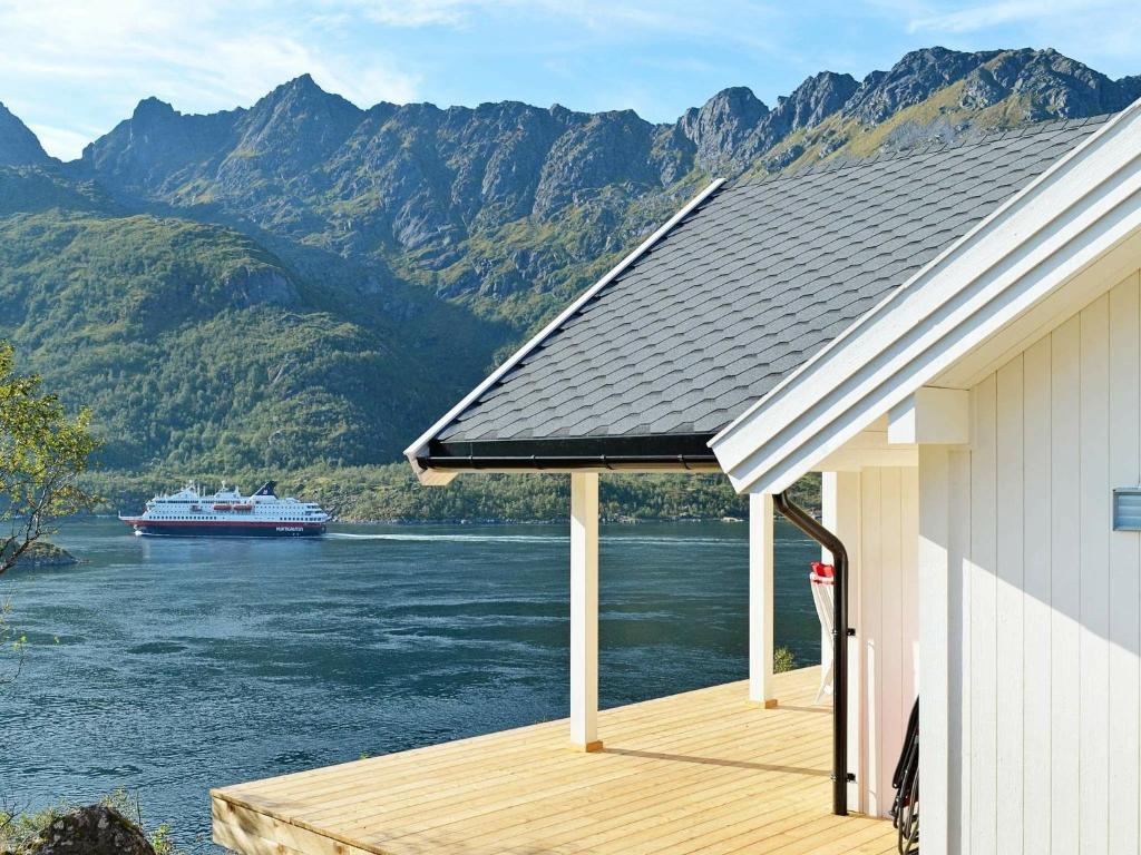 a house with a deck with a boat in the water at 8 person holiday home in Tengelfjord in Tengelfjorden