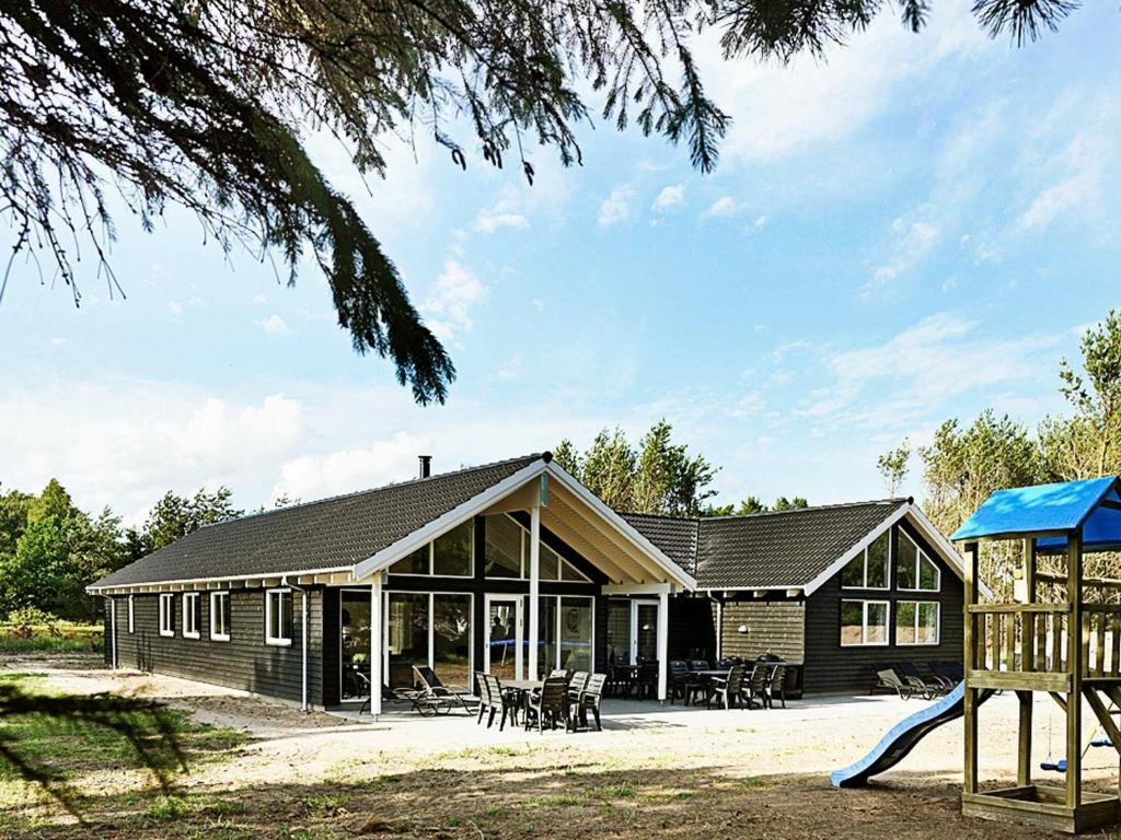 une maison avec une aire de jeux en face dans l'établissement 19 person holiday home in Nex, à Bedegård