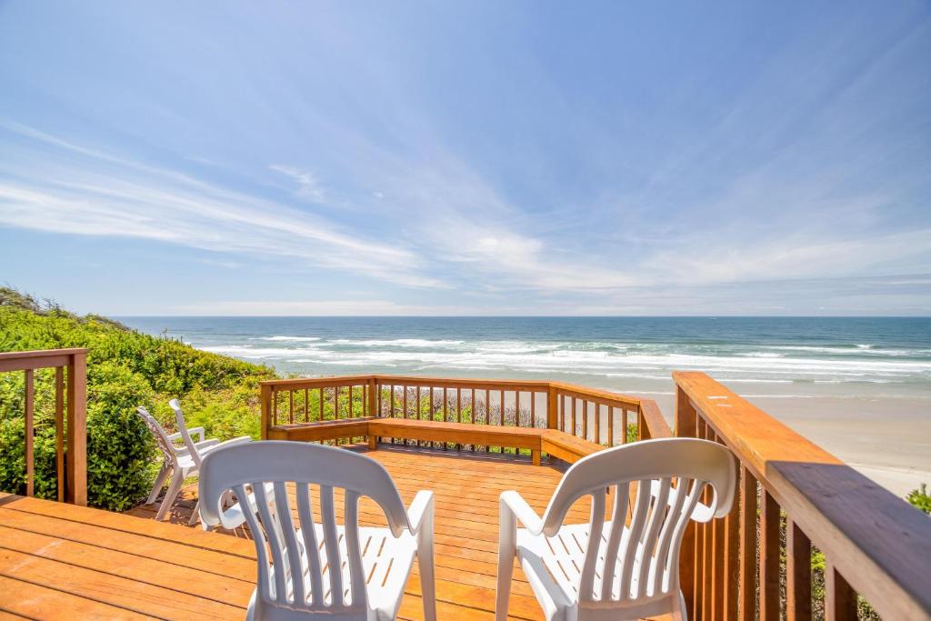 eine Terrasse mit Stühlen, einem Tisch und dem Strand in der Unterkunft Captain Jack's in South Beach