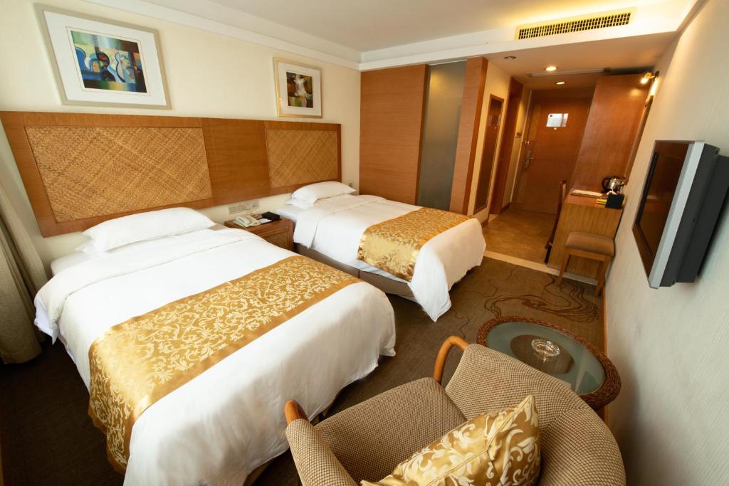 a hotel room with two beds and a television at Huangshan Leaf Spring Resort Hotel in Huangshan City