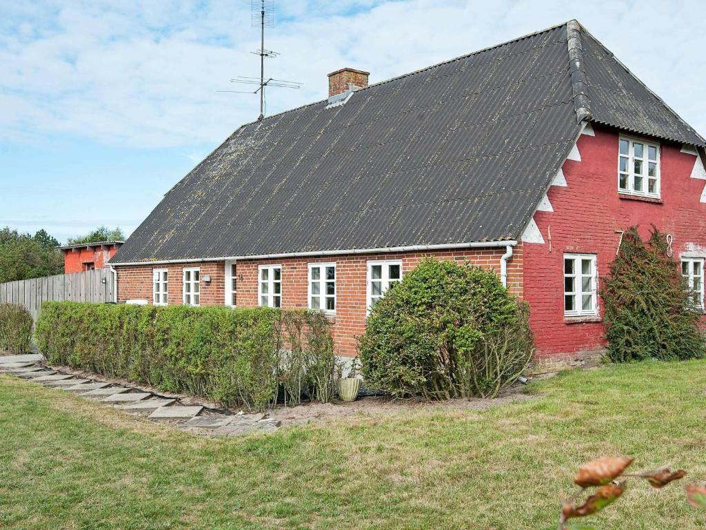 uma casa de tijolos vermelhos com um telhado preto em 5 person holiday home in R m em Toftum