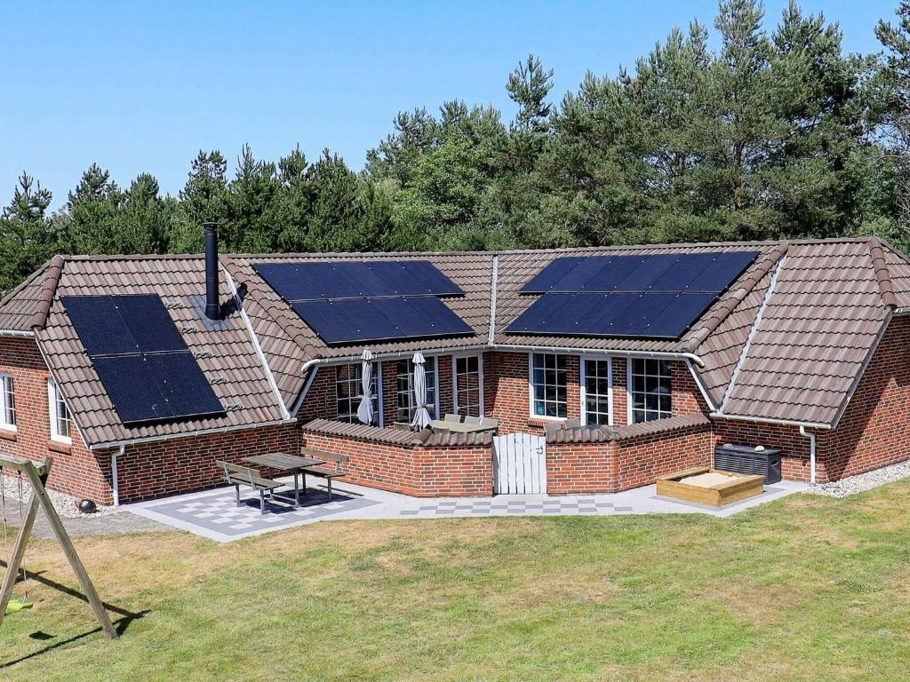 dom z kilkoma panelami słonecznymi na dachu w obiekcie 10 person holiday home in Oksb l w mieście Øster Vrøgum