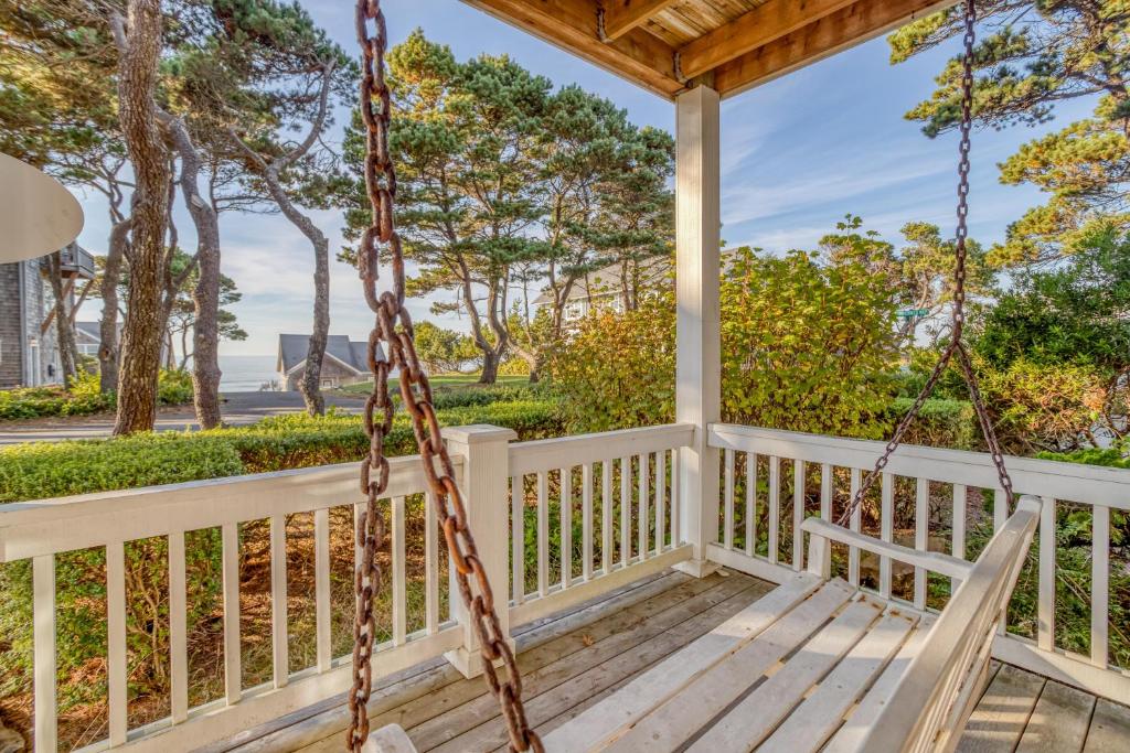 a porch with a swing and a view of the ocean at Sunset 389 in Depoe Bay