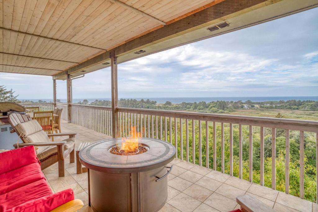 eine Terrasse mit einer Feuerstelle auf einer Terrasse in der Unterkunft Neskowin Eyrie - Meredith Lodging in Neskowin