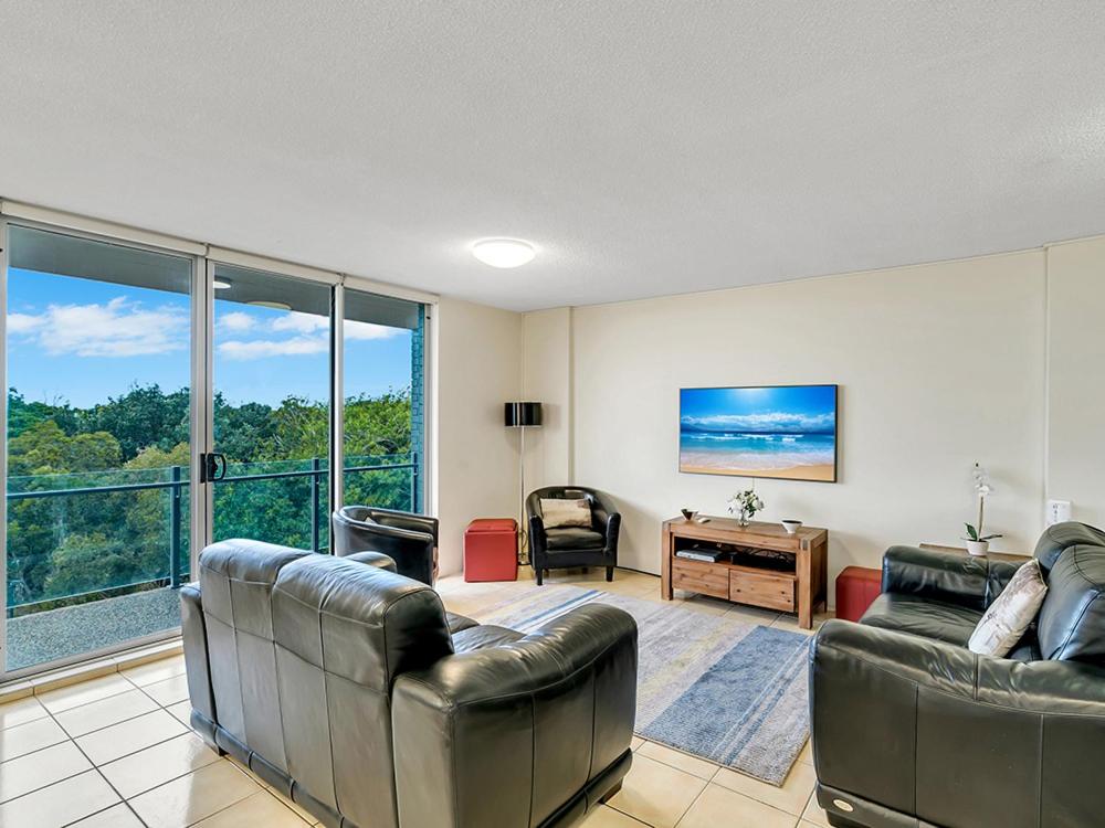 a living room filled with furniture and a large window at Tradewinds Apartments in Coffs Harbour