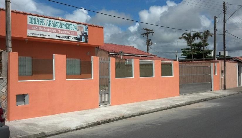 an orange building on the side of a street at Pousada Iguape Apartamentos - Unidade Ilha Comprida in Ilha Comprida