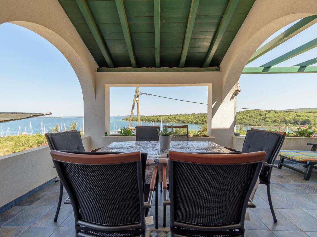 une salle à manger extérieure avec une table et des chaises dans l'établissement Charming Holiday House in a quiet area large covered terrace with great sea view, à Veli Rat