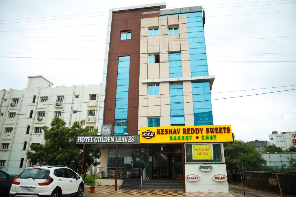 um edifício com um carro estacionado em frente em Hotel Golden Leaves em Hyderabad