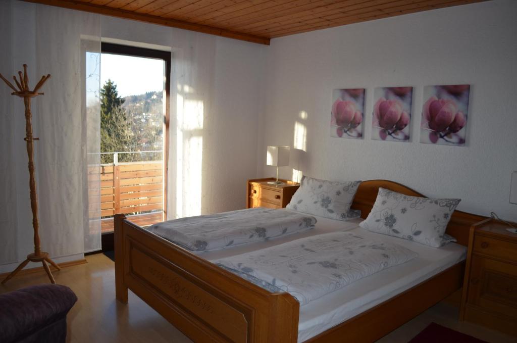 ein Schlafzimmer mit einem Bett und einem großen Fenster in der Unterkunft Gästehaus Haller in Bodenmais
