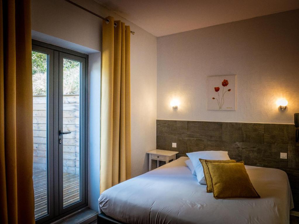 a bedroom with a bed and a large window at Le Belvedere in Vallon-Pont-dʼArc