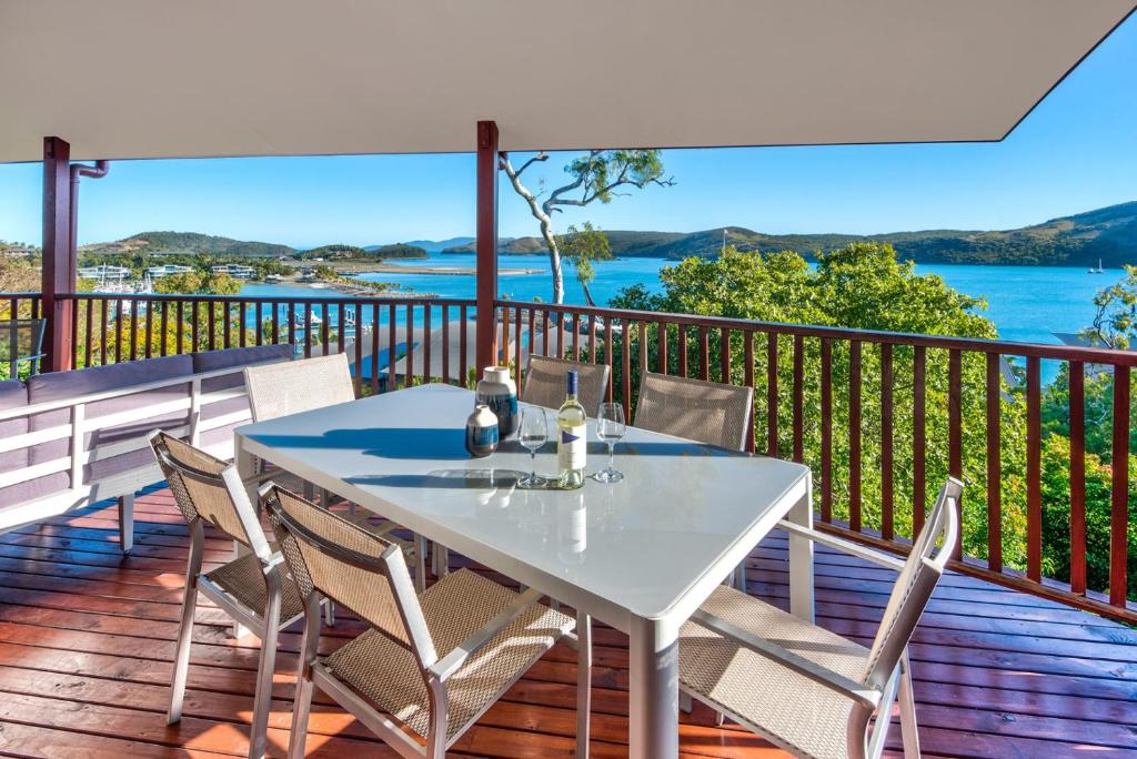 einen Tisch auf einer Terrasse mit Blick auf das Wasser in der Unterkunft Casuarina 18 Ocean View House Central Location BBQ Golf Buggy in Hamilton Island