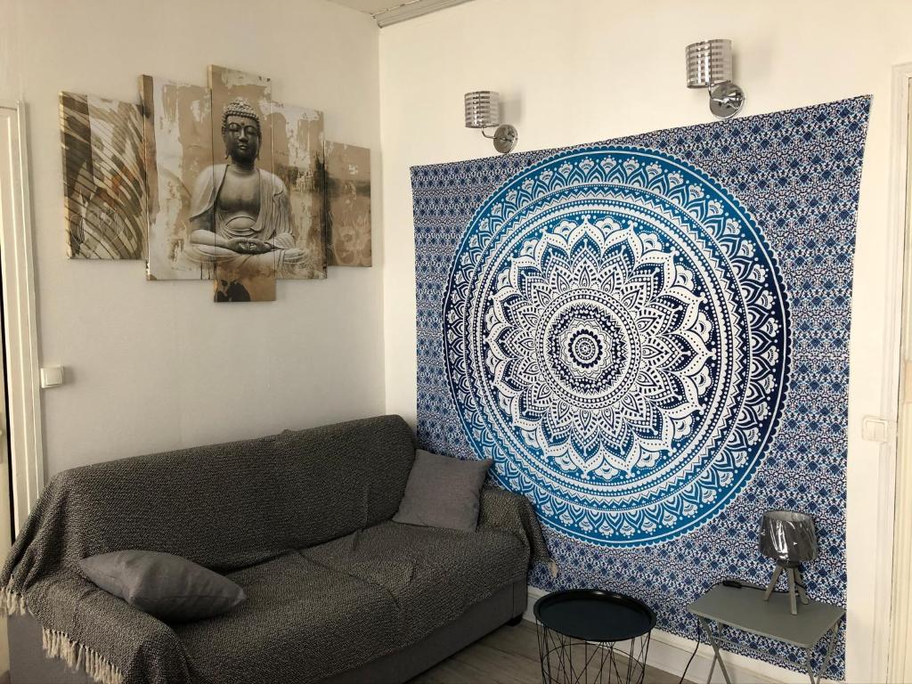 un salon avec un canapé et un mur avec un médaillon dans l'établissement Avec un minimum de 3 nuits Studio 80 m de la mer et 300 m des commerces, au Tréport