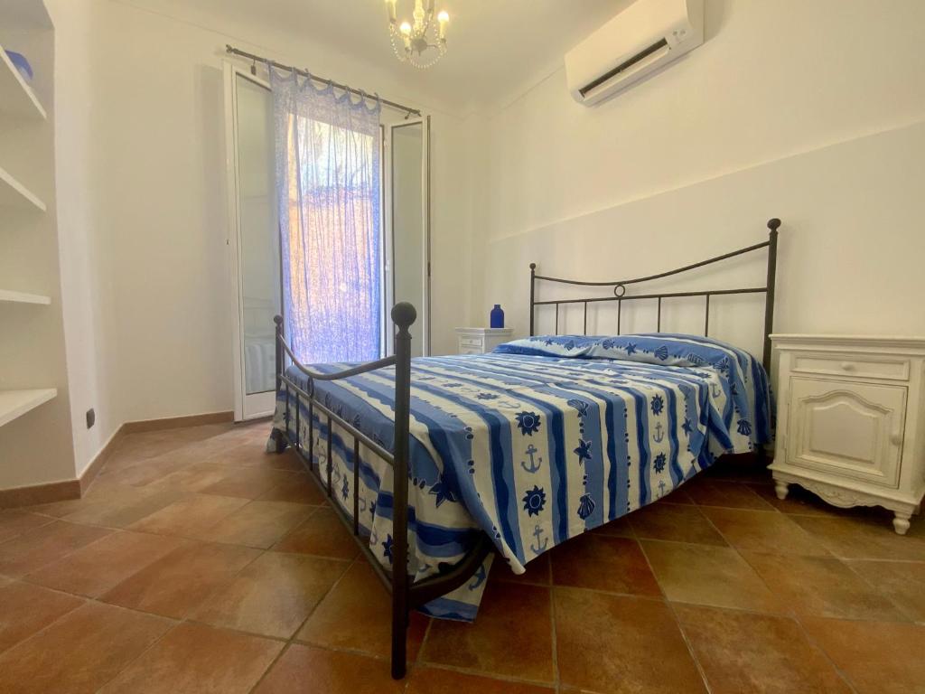 1 dormitorio con 1 cama con edredón azul y blanco en L'Ancora Blu, en Imperia