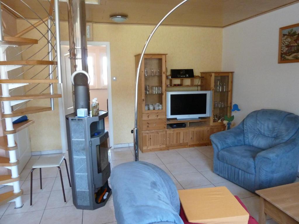 ein Wohnzimmer mit einer Treppe und einem TV in der Unterkunft Okulus in Pretzfeld