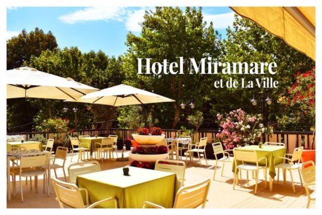 restauracja ze stołami, krzesłami i parasolami w obiekcie Hotel Miramare Et De La Ville w Rimini
