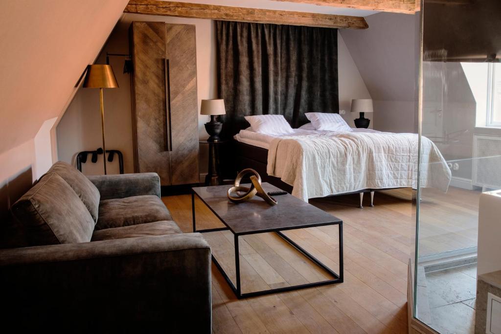 a living room with a bed and a couch at Hotell Visby Börs in Visby