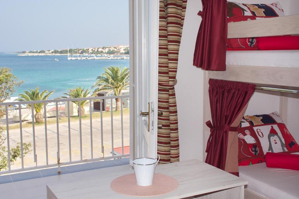 a room with a balcony with a view of the ocean at Hostel Casa La Cha in Novalja