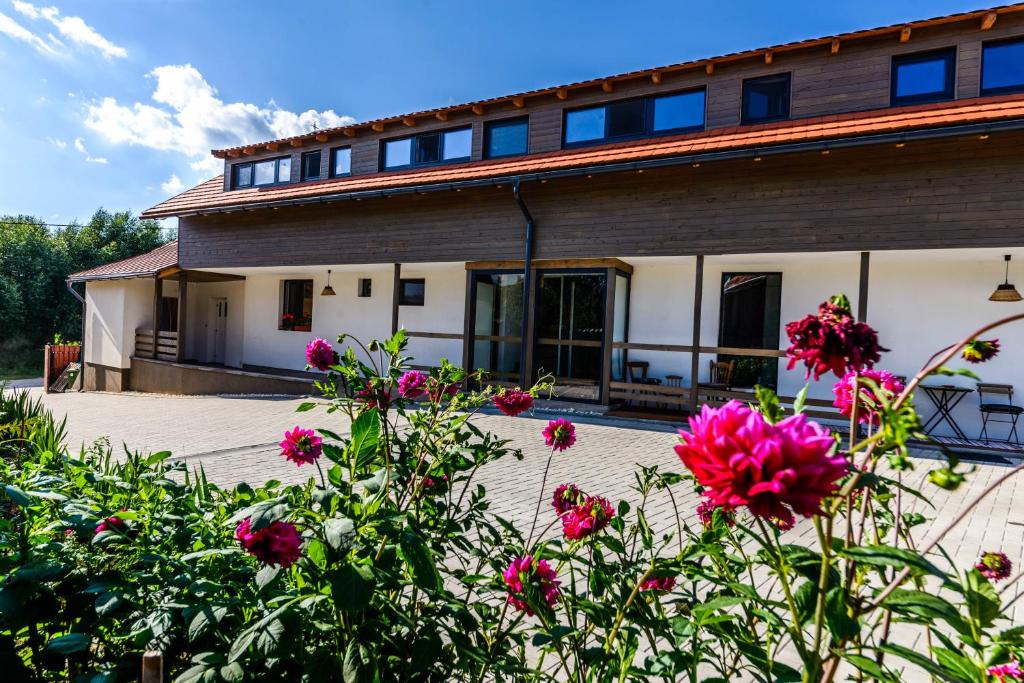 uma casa com flores em frente em Lina Agropanzió em Tomeşti