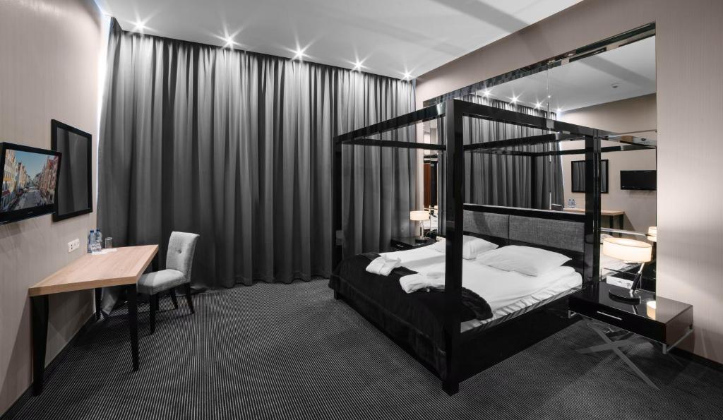 a bedroom with a black bunk bed and a desk and a desk at Focus Hotel Premium Elbląg in Elblag