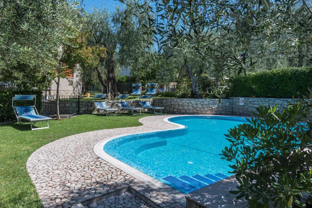 uma piscina num quintal com uma parede de pedra em appartamento casa stefi n1 em Malcesine