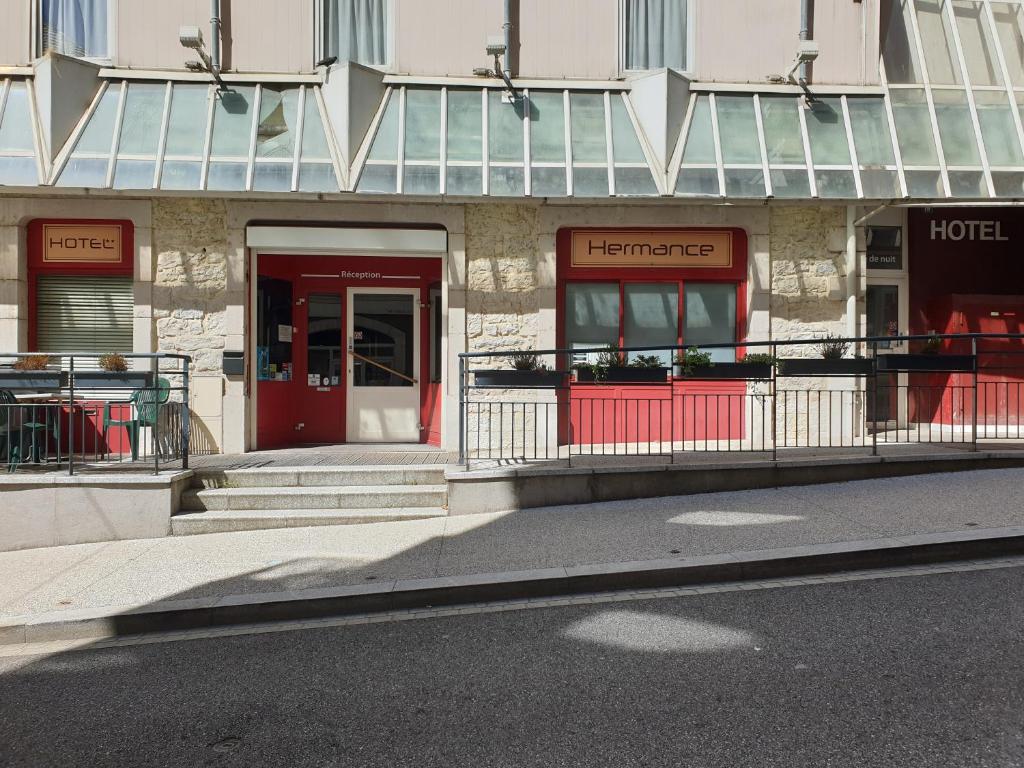 a building with a red door and a hotel at Hôtel Hermance in Bellegarde-sur-Valserine