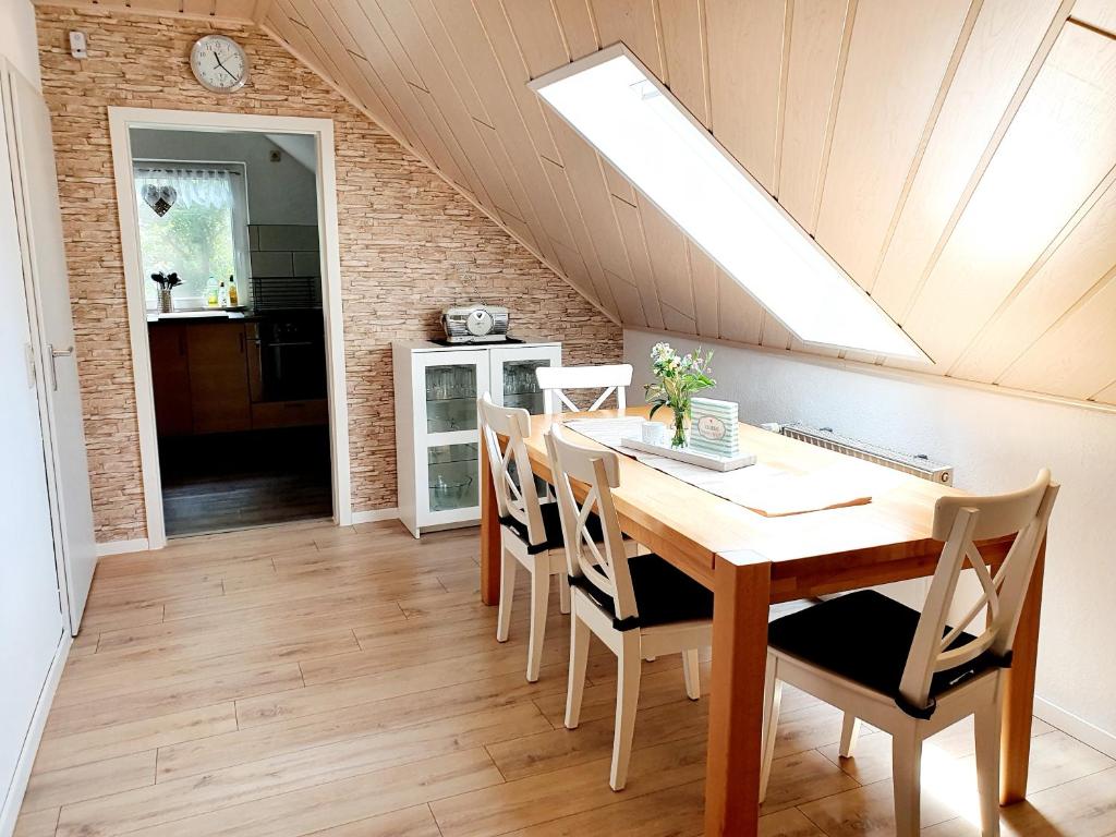 ein Esszimmer mit einem Holztisch und einem Dachfenster in der Unterkunft Ferienwohnung Wipperau I in Uelzen