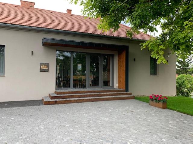 a building with a large glass door and a porch at Völgy Vendégház in Etyek