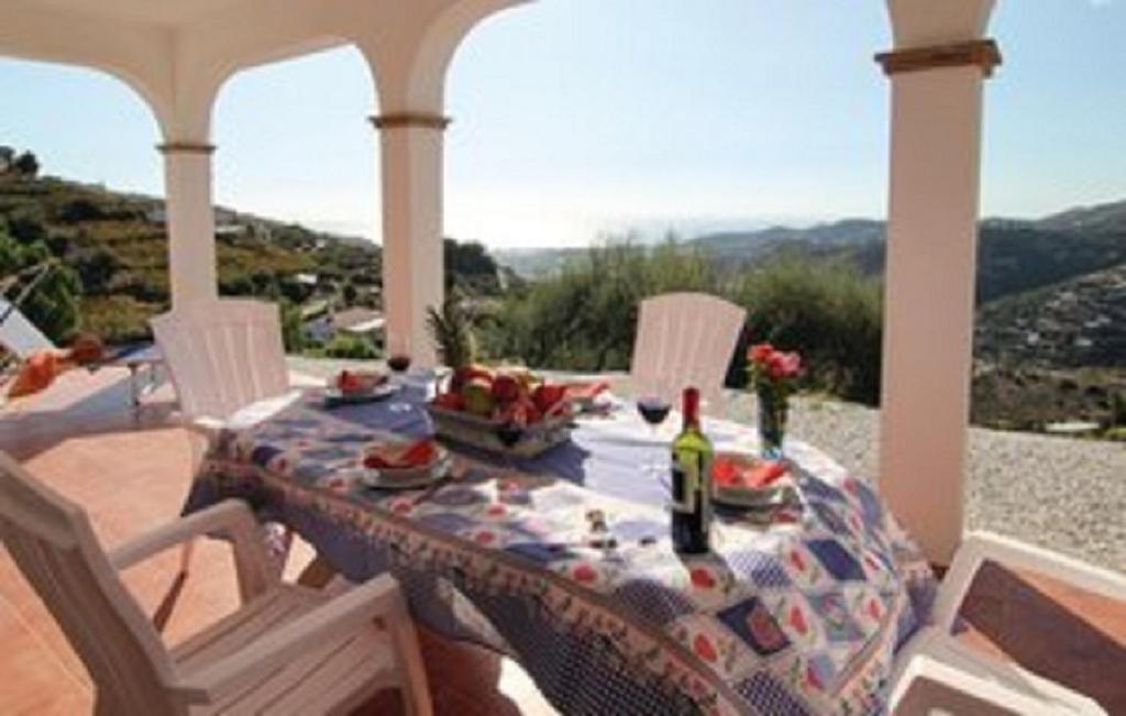 een tafel met eten en een fles wijn op een veranda bij Casa Rural Torrox - Cortijo Latero in Torrox