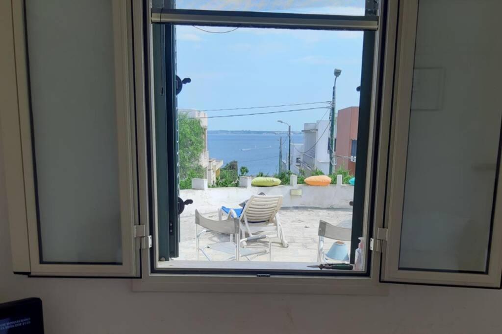 ventana con vistas a una mesa y sillas en appartamento in pineta vista mare, en Santa Caterina di Nardò