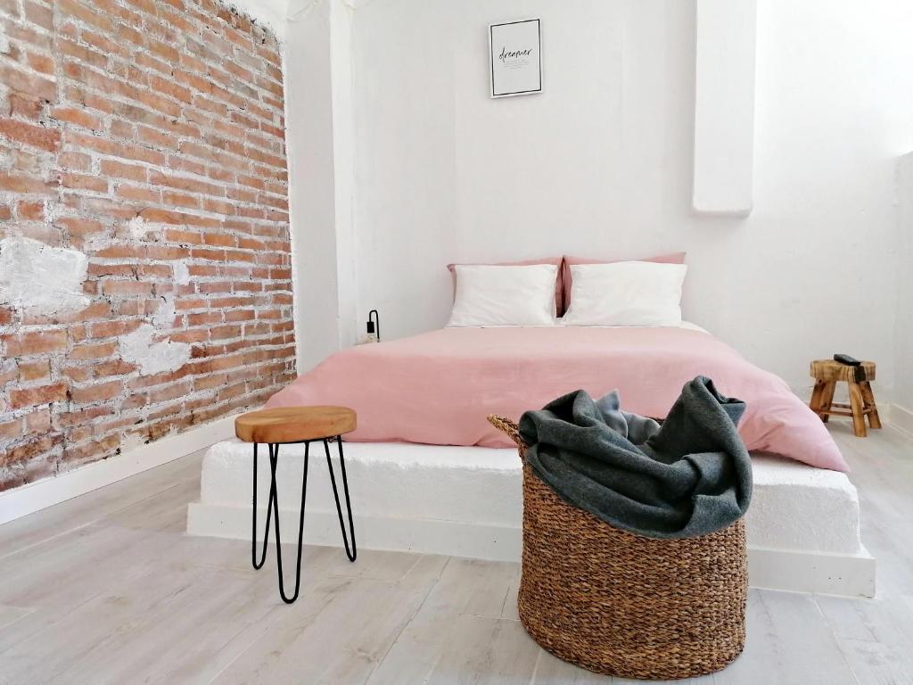 a bedroom with a bed and a chair and a brick wall at Refúgio do Esquilo in Marinha Grande