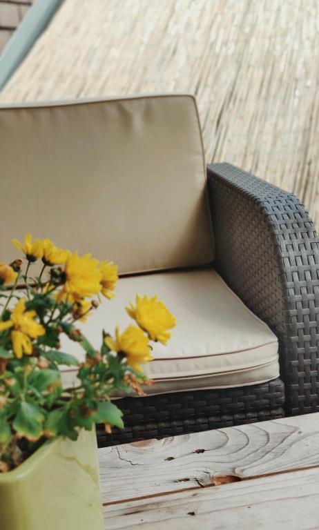 a chair with yellow flowers next to a plant at B&amp;B Aquavert &amp; Wellness in Tournai