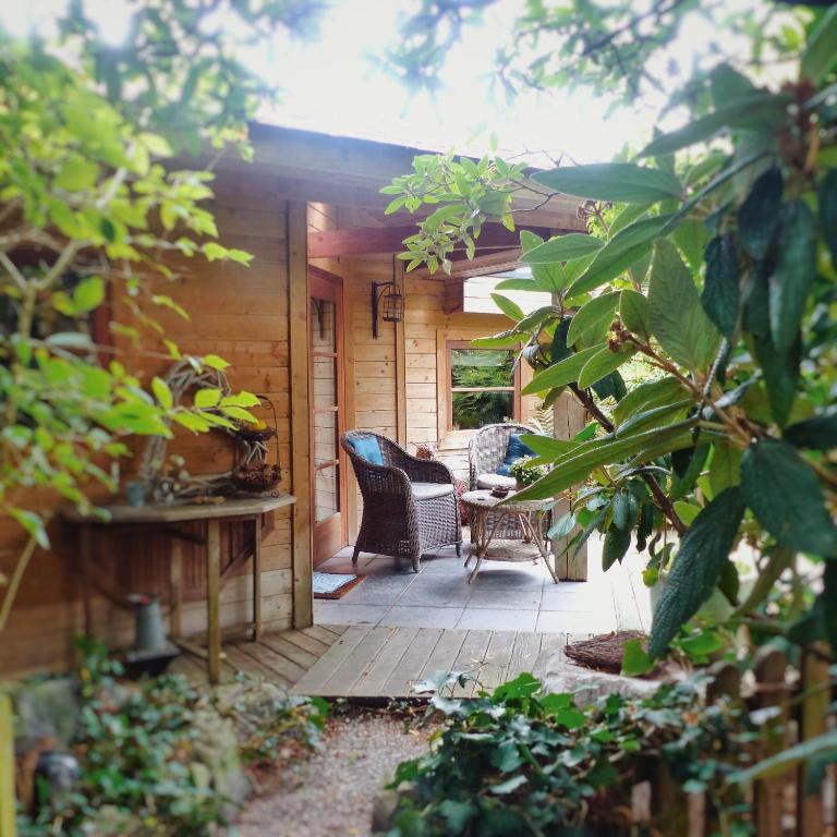 a porch of a house with chairs and a table at B&amp;B Aquavert &amp; Wellness in Tournai