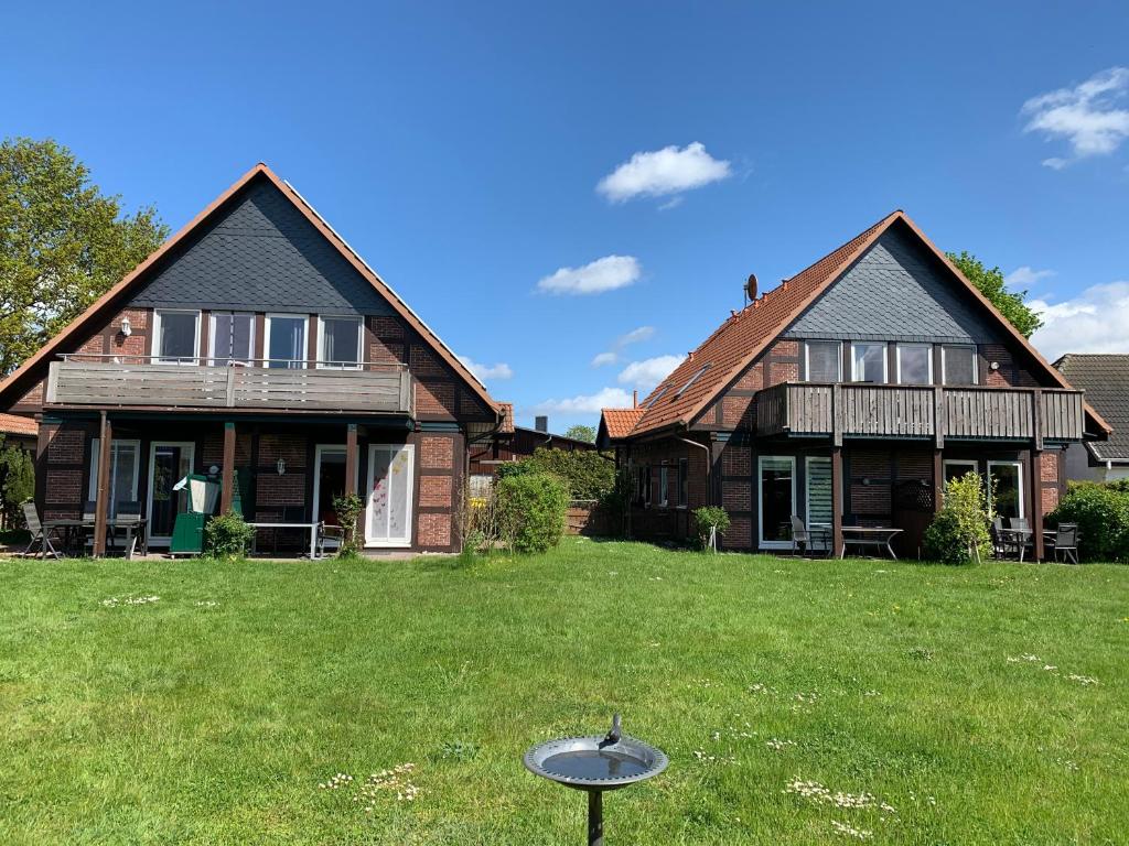 ein Haus mit einem Garten mit Frisbee im Gras in der Unterkunft Vineta Ferienwohnungen in Mölschow