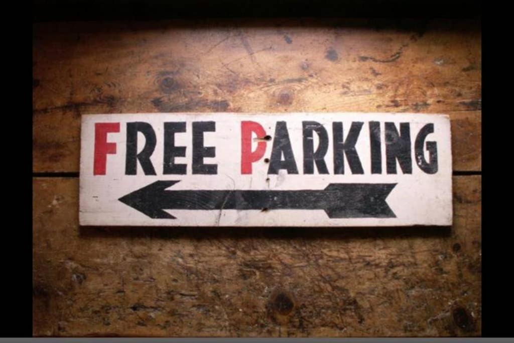 un letrero de aparcamiento gratuito en una pared de madera en Pop Art Pad heart of Old Town with parking!, en Hastings