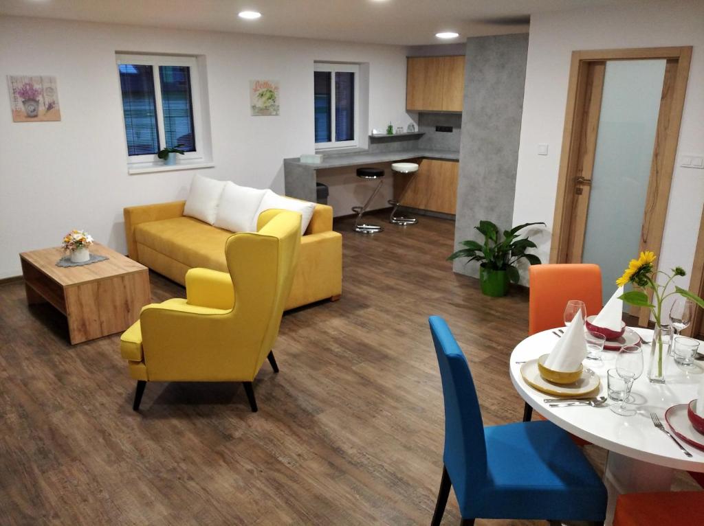 a living room with a couch and a table and chairs at Shiny Apartmán in Spišská Nová Ves