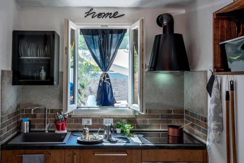 eine Küche mit einem Waschbecken und einem Fenster in der Unterkunft Le case di Matteo il mare in Marina di Pisa