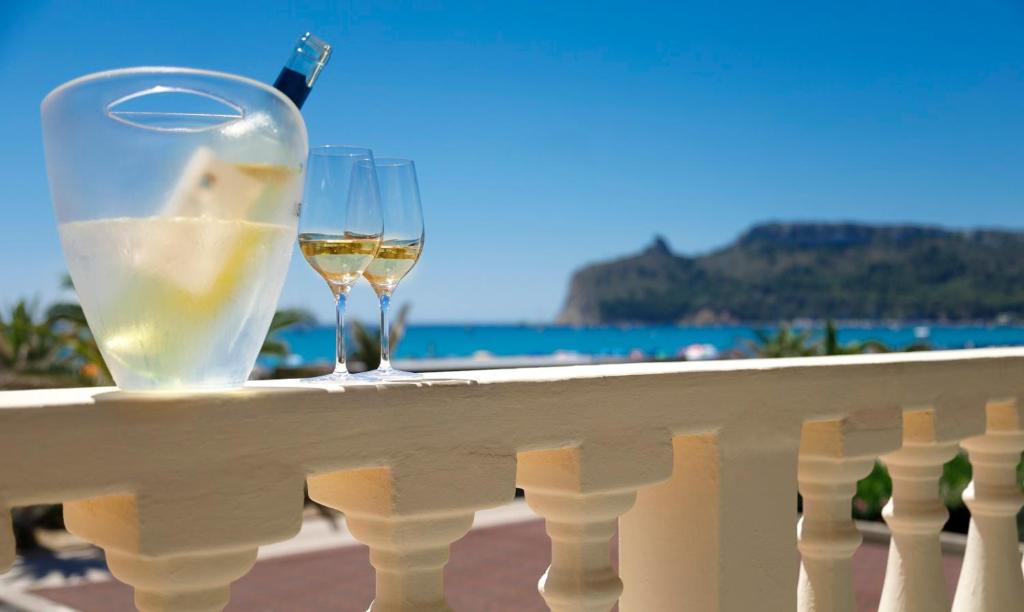 a glass of wine and a wine bottle on a balcony at Hotel La Villa Del Mare in Cagliari