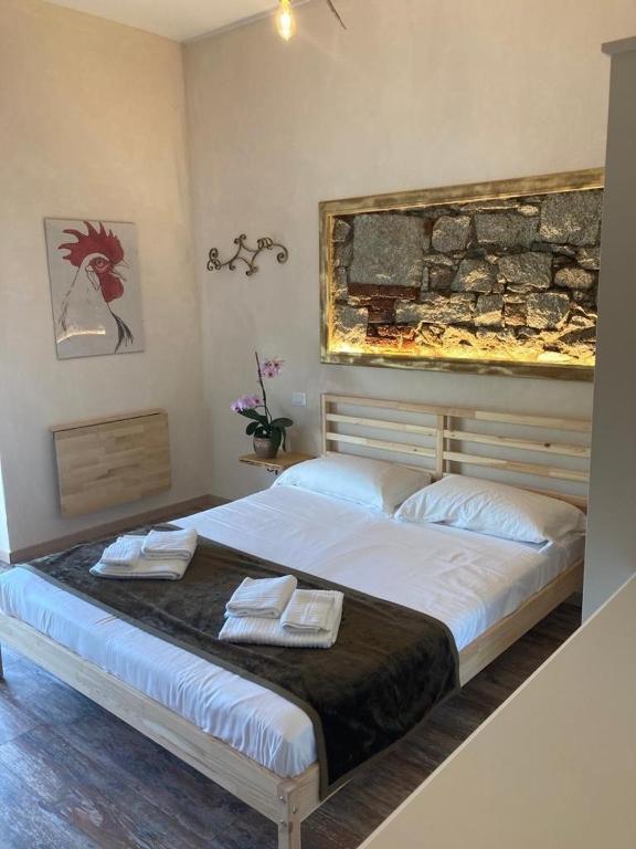 a bedroom with a large bed with two towels on it at Locanda Il Gallo in Baveno