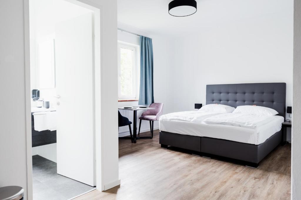 a bedroom with a bed and a table with a chair at Müllner Smart Hotel Wien Self Check In in Vienna