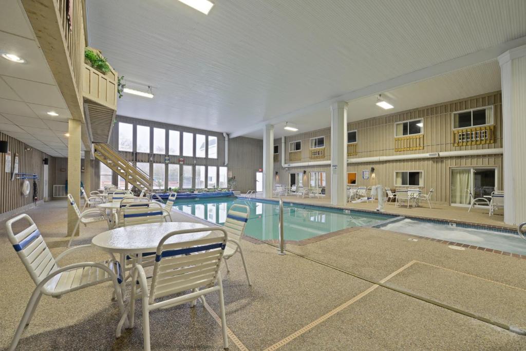una piscina con mesas y sillas en un edificio en Sandwich Lodge & Resort, en Sandwich