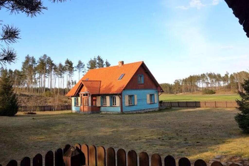 a house with an orange roof in a field at Dworek Sominy in Sominy