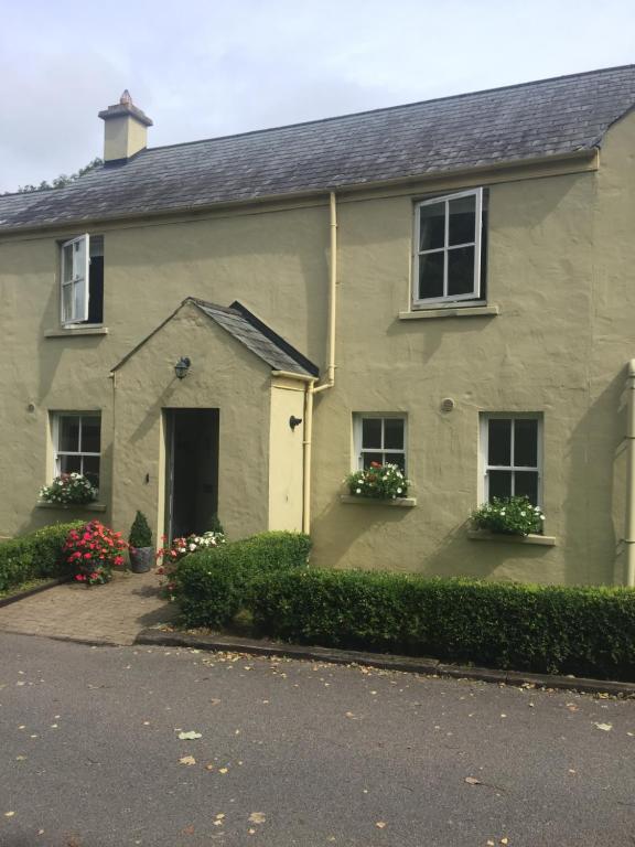 uma casa com duas janelas e flores numa garagem em No.14 em Bunratty