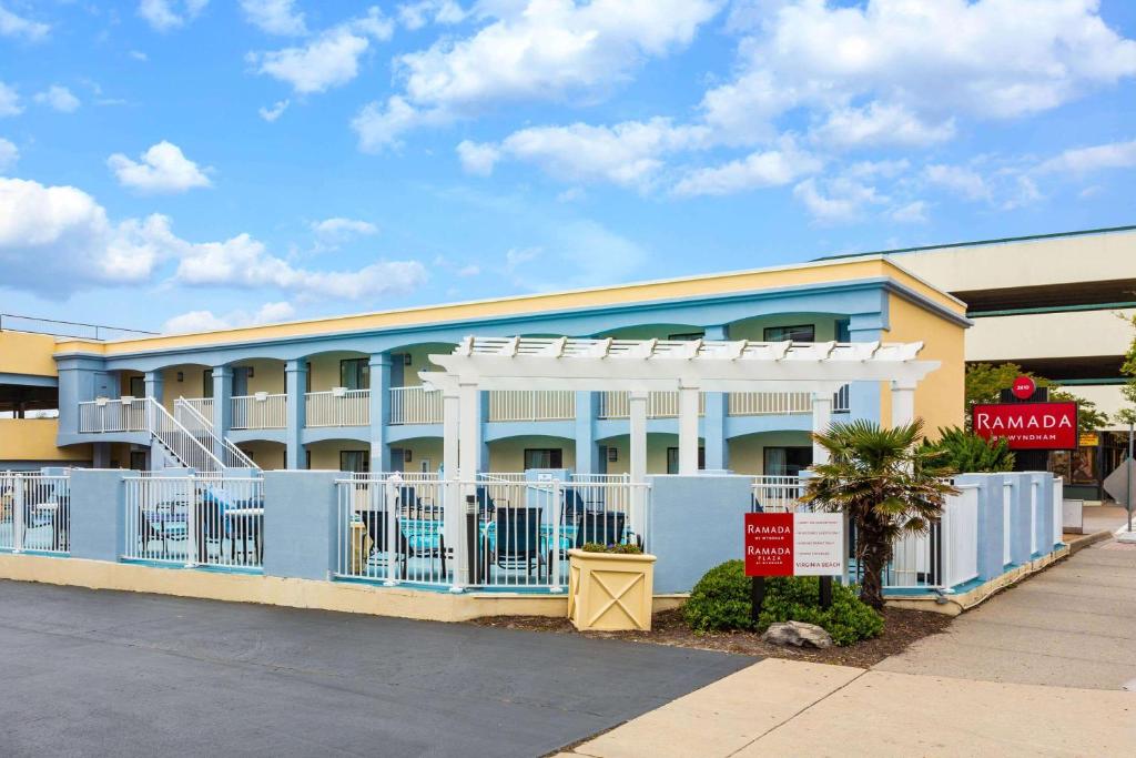 a blue building with a white fence in front of it at Ramada by Wyndham Virginia Beach in Virginia Beach